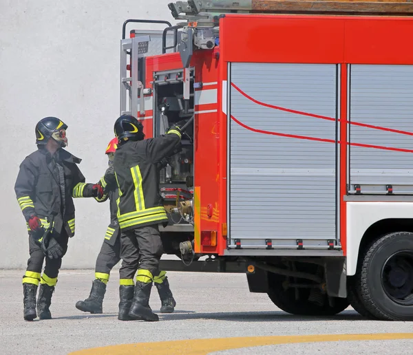 Camions de pompiers et pompiers avec uniformes et casque de protection — Photo