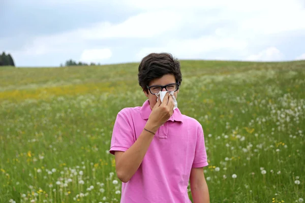 Allergische adolescent met glazen blaast zijn neus — Stockfoto