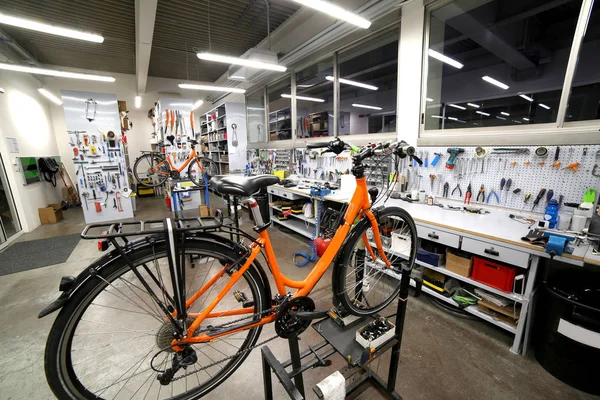 Oranje fiets gebroken in de mechanische werkplaats voor reparatie — Stockfoto