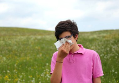 Alerjik çocuk burnunu beyaz mendil ile springtim içinde darbeler.