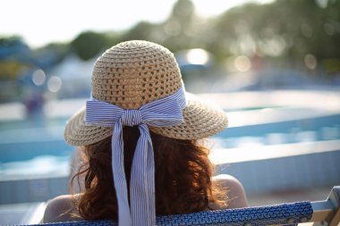 Hasır şapka özel resort e üzerinde güneşlenme ile kadın