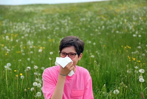 Child with allergy blows his nose in the middle of the meadow wi — Stock Photo, Image