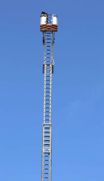 Пожарный над длинной лестницей с металлической корзиной управления — стоковое фото