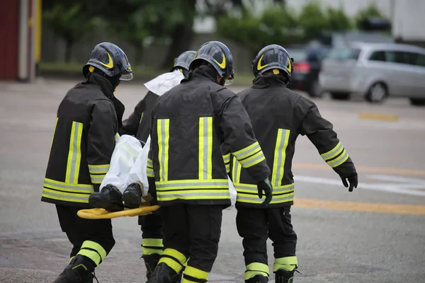 Firefighters with the stretcher after a tragic road accident — Stock Photo, Image