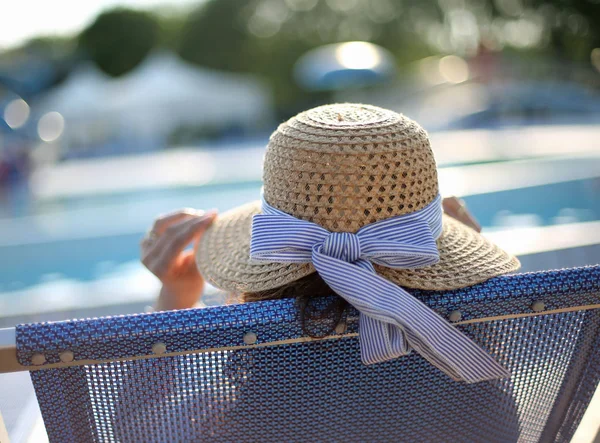 Person with straw hat in the exclusive resort on the edge of the