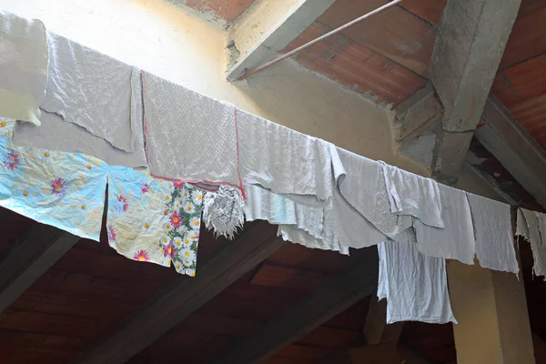 Trapos y canovares húmedos colgados para secar en el ático de la casa — Foto de Stock