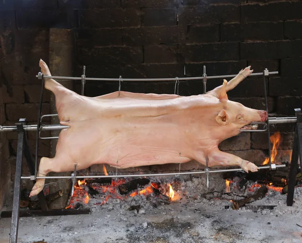 Skewer of a large roasted roasted pork with slow fire — Stock Photo, Image