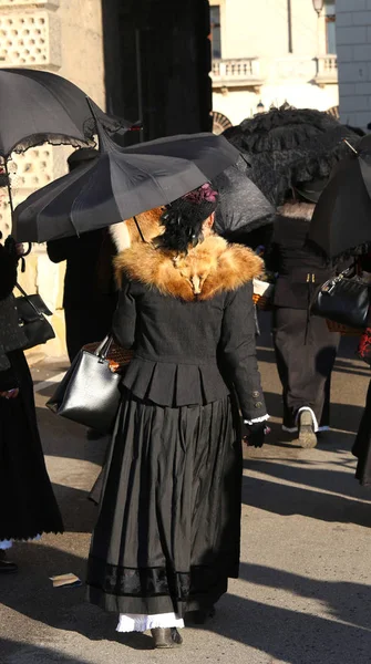 Women dressed in vintage clothes and a black umbrella to protect — Stock Photo, Image