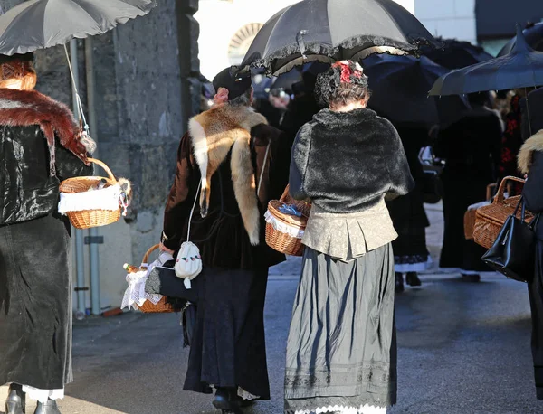 Mulheres vestidas com roupas vintage e um guarda-chuva preto para proteger — Fotografia de Stock