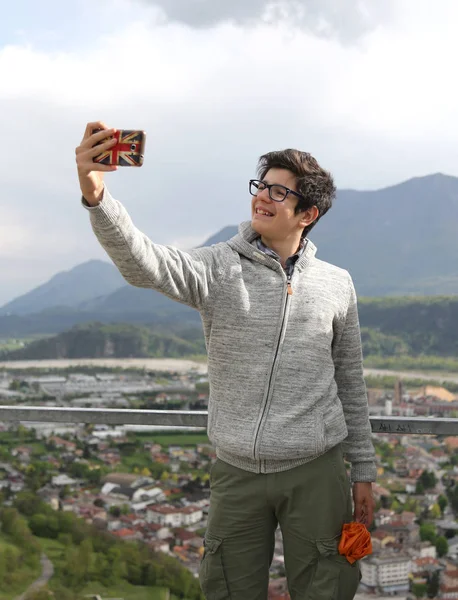 Giovane ragazzo con smartphone moderno fa un selfie — Foto Stock