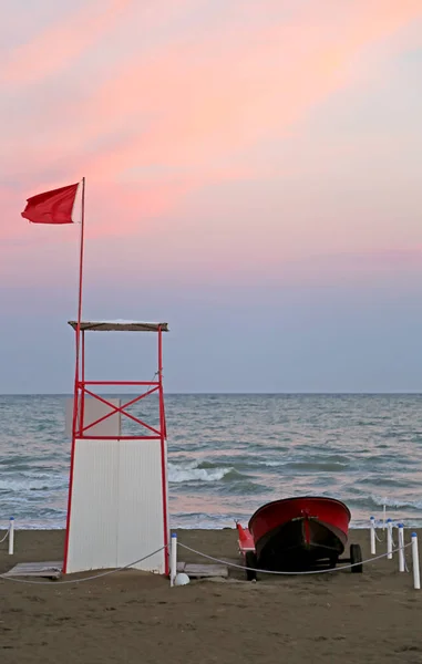 Torre di bagnino con bandiera rossa al mare — Foto Stock