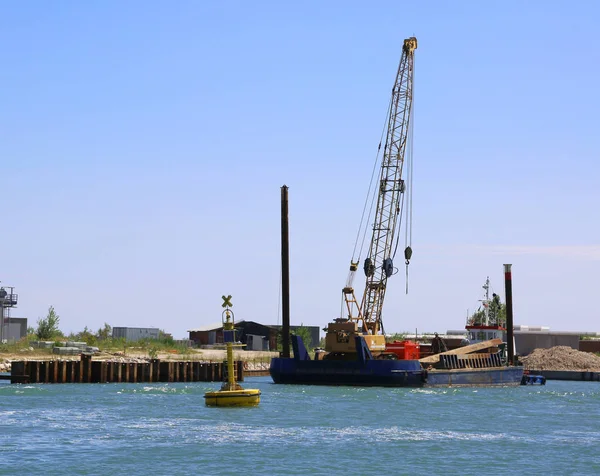 Gru in un cantiere navale per la costruzione di una diga sul mare — Foto Stock