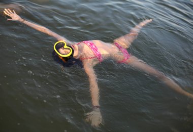 Deniz su üzerinde yüzen süre dalış maske ile küçük kız