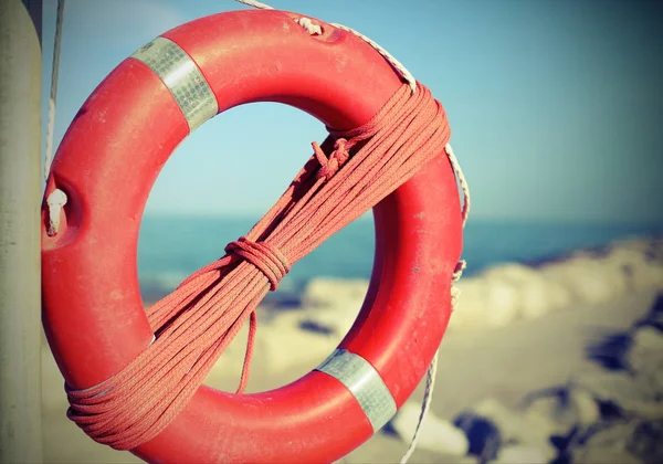 Kayalar yakın kişi için turuncu lifebuoy