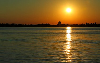 Sarı güneş batımında reklam su yansımaları ile