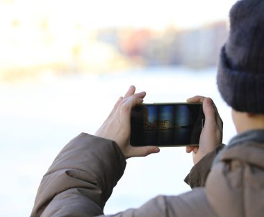 Çocuk bir kış gezi sırasında belgili tanımlık smartphone ile fotoğraf çeker