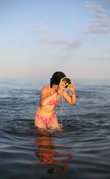 Liten flicka med dykning mask medan du spelar på havsvatten — Stockfoto