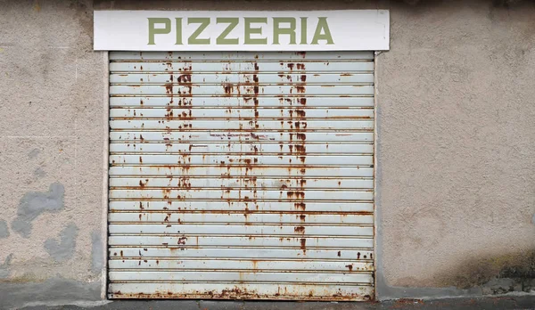 Ondertekenen met Pizzeria tekst met de poort gesloten vanwege de econ — Stockfoto