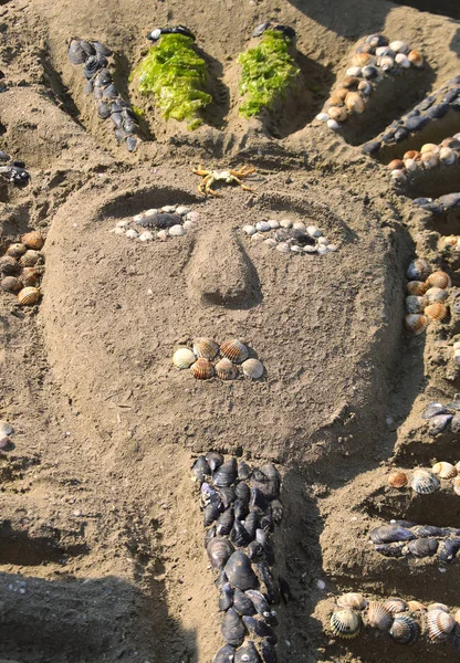 Sarcófago feito por crianças na praia do mar com areia — Fotografia de Stock