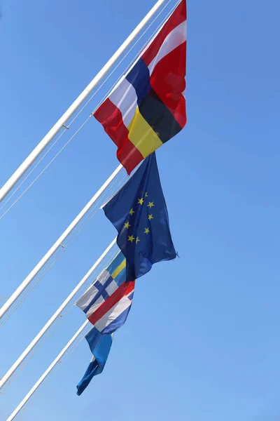 Vlajky a Evropskou vlajku a modrá obloha na pozadí — Stock fotografie
