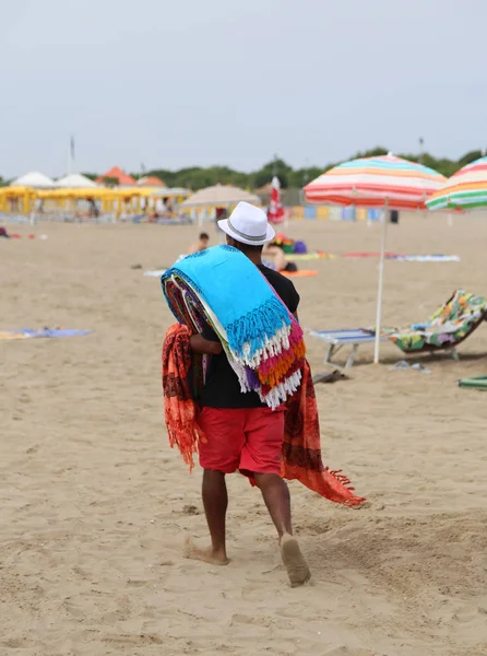 Missbräuchlicher Spaziergänger am Strand, der Baumwollstoffe verkauft — Stockfoto