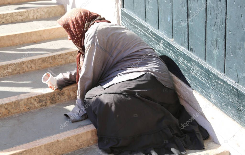 gypsy woman with headscarf and long skirt begging people
