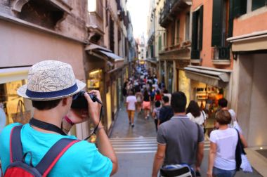 Genç fotoğrafçı insanlar karga içinde yürürken, insanlar için bir fotoğraf çeker