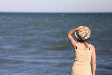denizin önünde hasır şapkalı kadın