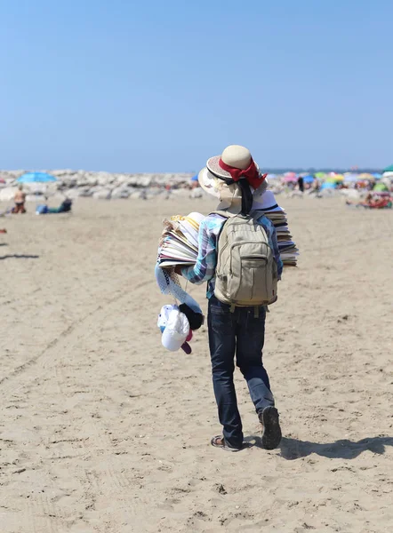 Caminante con muchos sombreros pasea por la playa —  Fotos de Stock