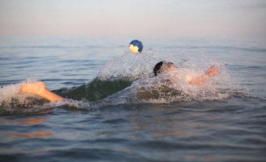 Genç çocuk denizde su polo oynuyor