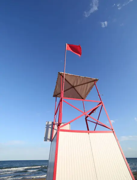 Turret of lifeguard on the beach with the red flag — Stock Photo, Image