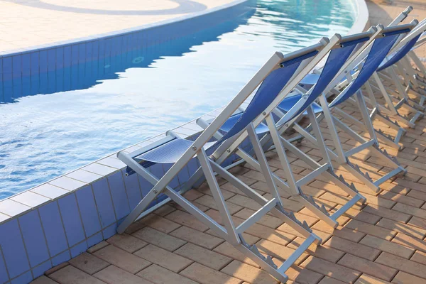 Lege ligstoelen aan de rand van het zwembad van de spa — Stockfoto