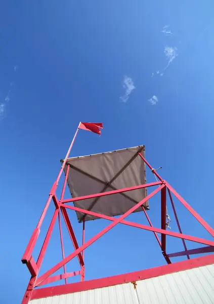 Башня спасателя на пляже с красным флагом — стоковое фото