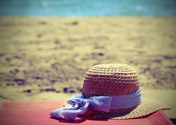 Cappello di paglia sulla spiaggia vicino all'oceano in estate — Foto Stock