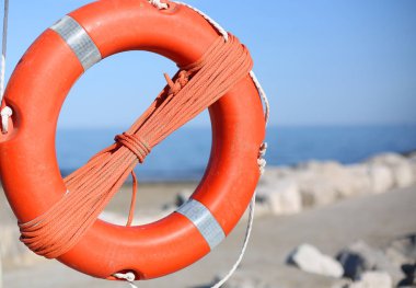 Deniz taşlara yakın kişi için turuncu lifebuoy