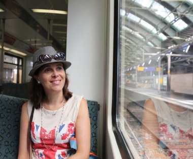 tren istasyonunda oturan şapkalı güzel kadın