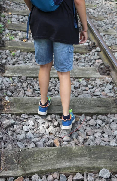 Criança caminha ao longo de trilhos ferroviários — Fotografia de Stock
