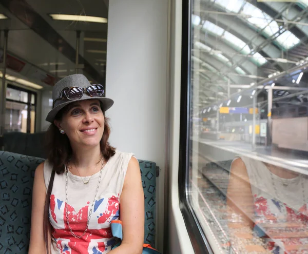 tren istasyonunda oturan şapkalı güzel kadın