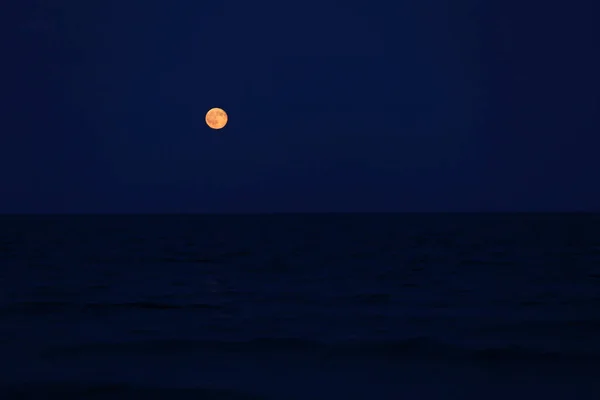 Red full moon on the horizon over the sea — Stock Photo, Image