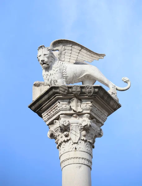 Columna con el león símbolo alado de la de Venecia en Italia — Foto de Stock