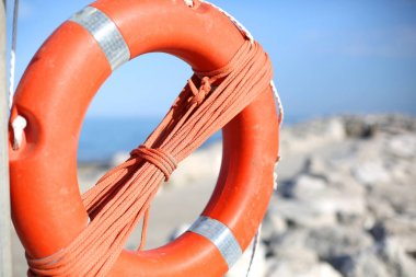 Deniz taşlara yakın kişi için turuncu lifebuoy