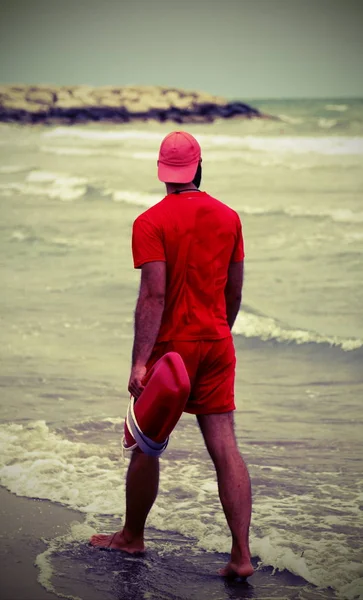 Bagnino muscolare con uniforme rossa — Foto Stock