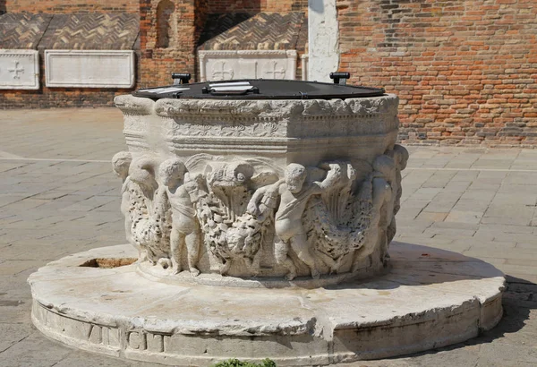 Ancient stone well in a square of a European city — Stock Photo, Image