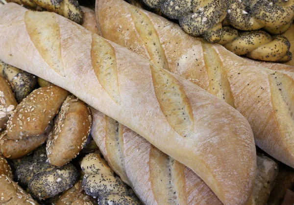 Pezzi di pane fresco in panetteria con pani profumati e sacchetto — Foto Stock