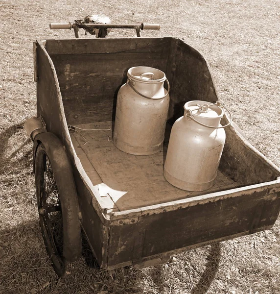 Carrinho de madeira com bicicleta velha para transportar o leite apenas levedado — Fotografia de Stock