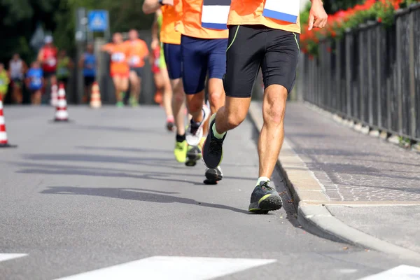Спортсмены бегают по улицам города — стоковое фото