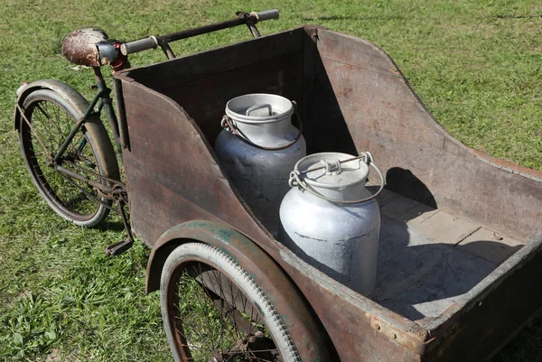 Повозка со старым велосипедом для транспортировки молока, только что заквашенного из т — стоковое фото