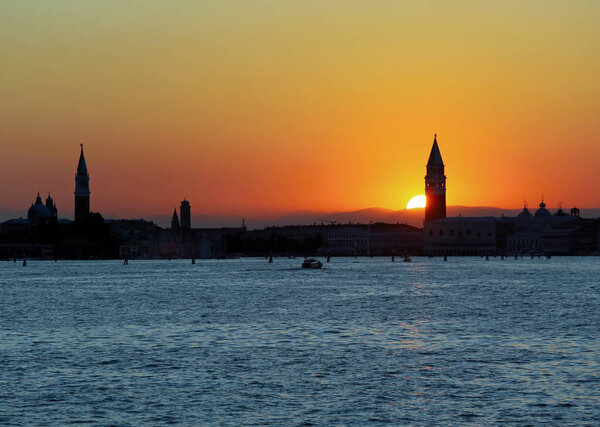 Sun at SUNSET in VENICE in Italy and the Campanile of St. Mark