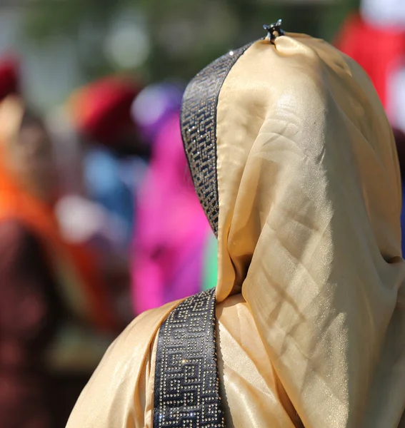 Kvinna med gyllene slöja under en religiös händelse på vägarna i — Stockfoto