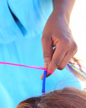 Bir saç modeli kaplama ile yapmaya çalışırken Afrikalı kadın el